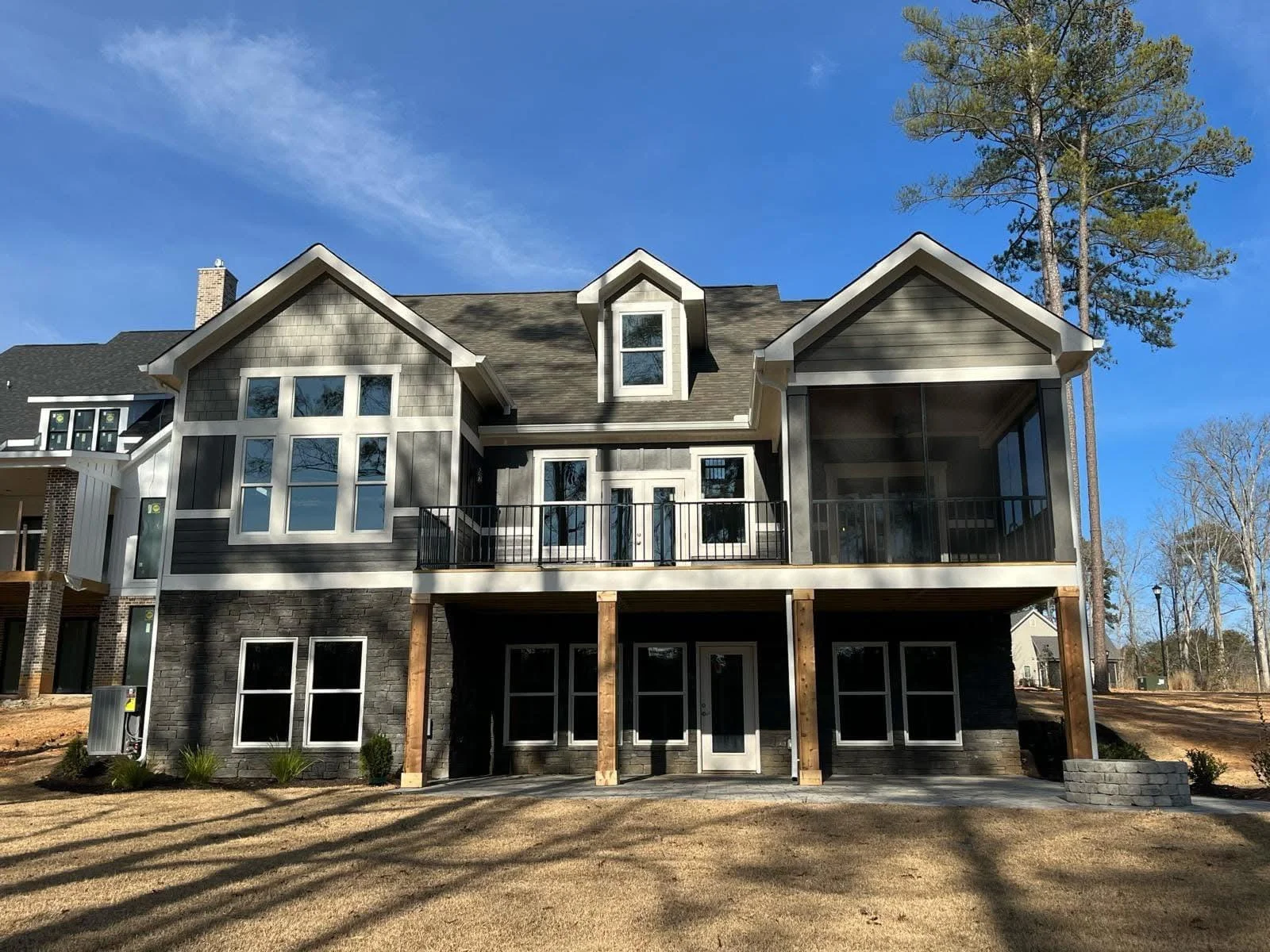 Multi-gable residential roof with asphalt shingles, dormers, and metal flashing on new construction home