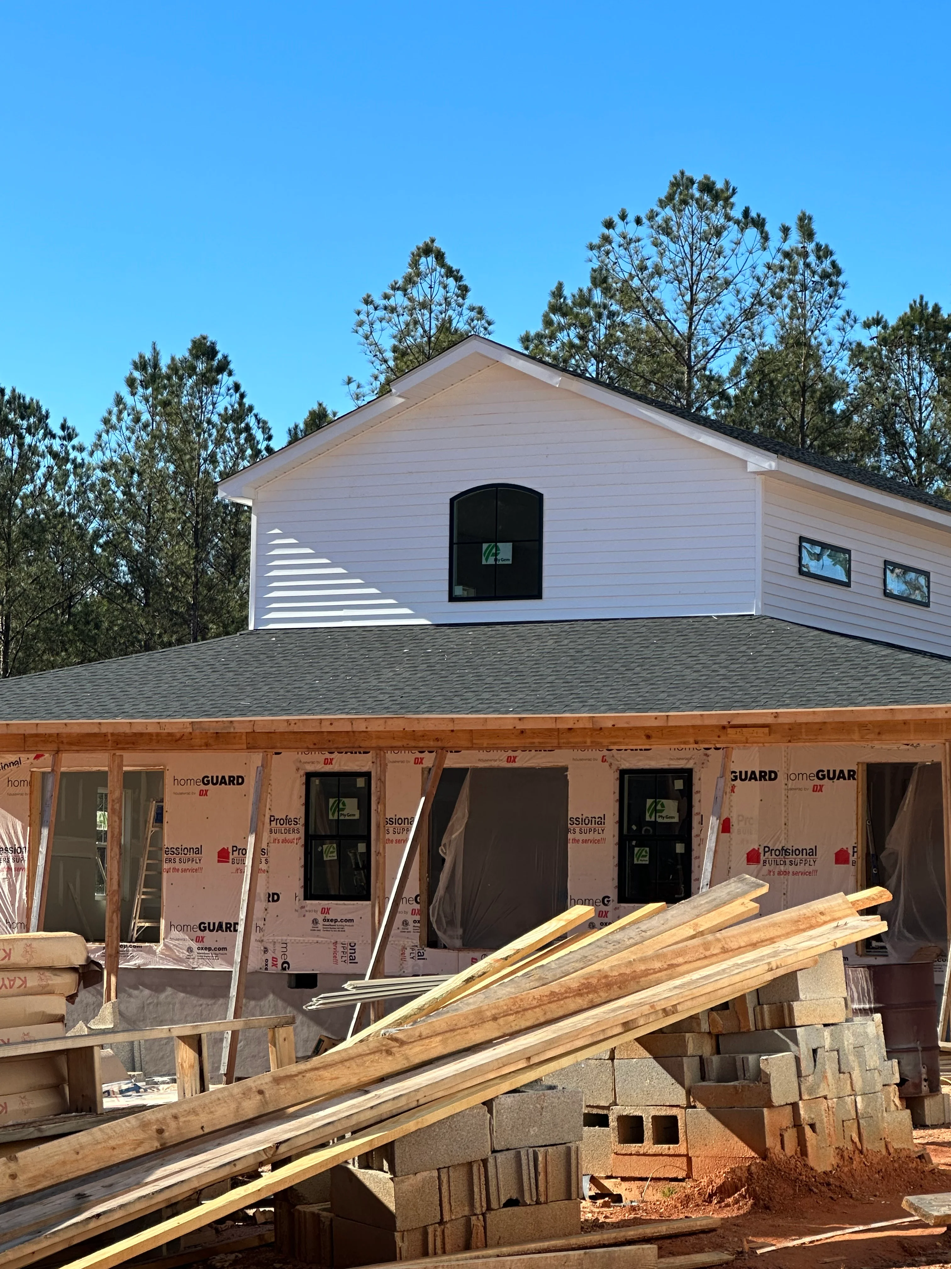 Gray asphalt shingle roof installation on residential home with gable design and white siding