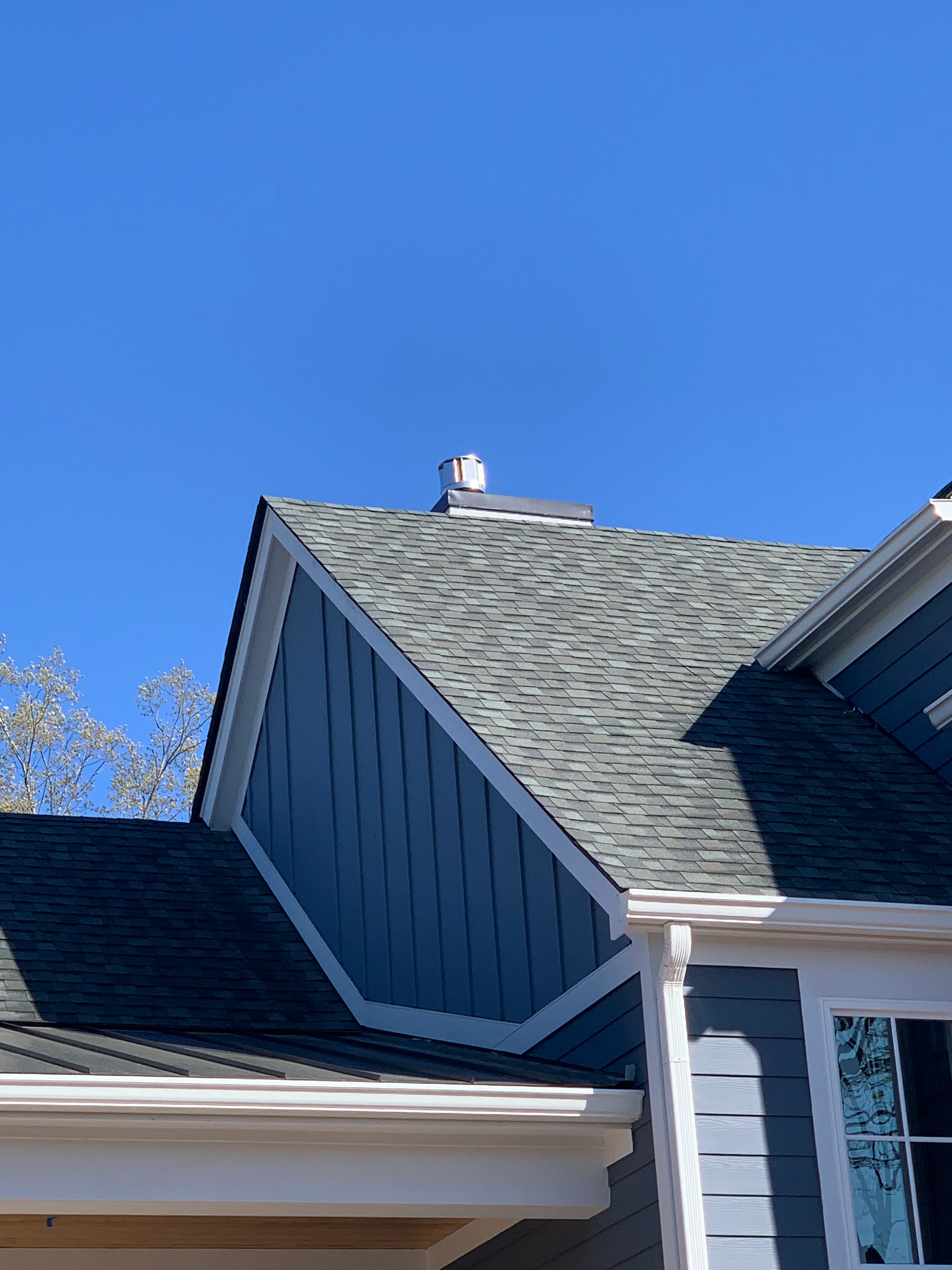 Slate gray architectural shingle roof with standing seam metal section and white trim